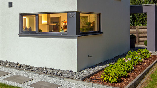 Haus Vettel schützt die helle Hausfassade mit einem Steinpfad rund um das Haus. (Foto: © BAUMEISTER-HAUS)